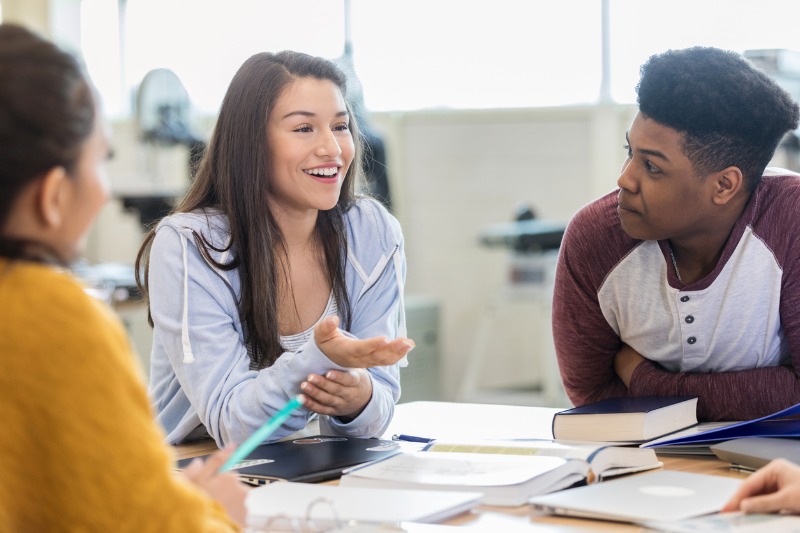 alunos de faculdade sendo instruidos por aluna durante processo de mentoring